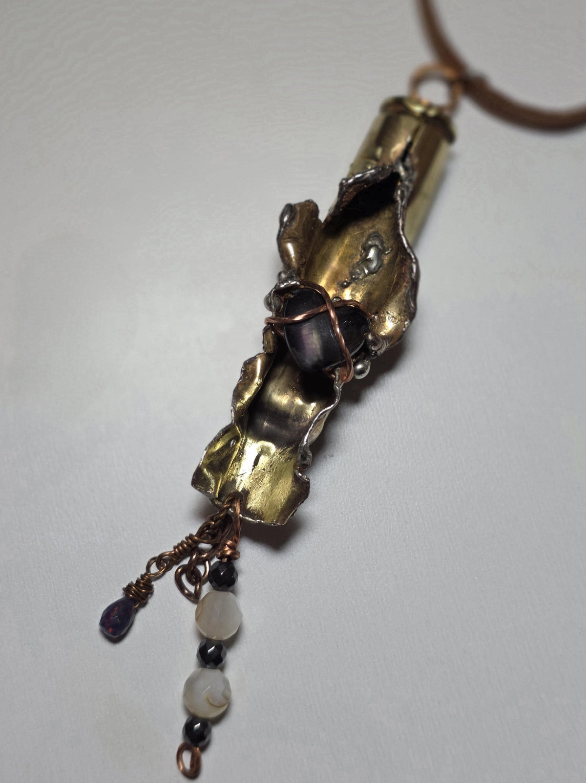 UNBROKEN “Center Mass” Shell Casing Pendant – Hematite Heart Necklace, Raw Metal Talisman, Survivor Jewelry, Rugged Artisan Pendant